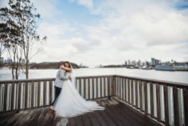 Newlyweds hug as the look out across Sydney Harbour after their wedding