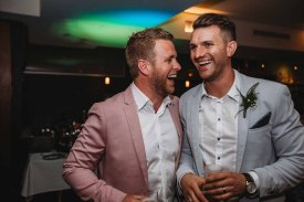 A groom shares a laugh with his MC during the wedding reception