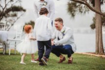 A groom greets his ring bearer and flower girl before the wedding